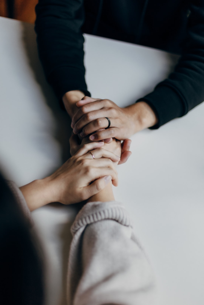 two people holding hands to signify the importance of reaching out to someone for help